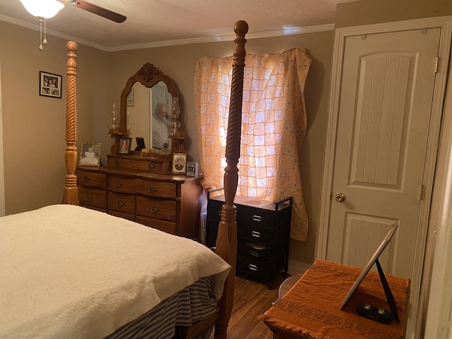 bedroom with hardwood / wood-style floors, ornamental molding, ceiling fan, and a textured ceiling