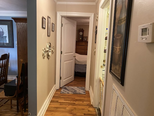 corridor featuring hardwood / wood-style floors and crown molding