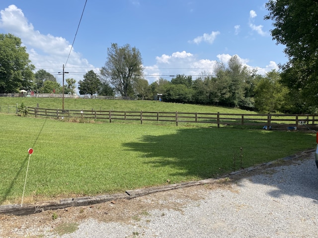 exterior space featuring a rural view and a yard