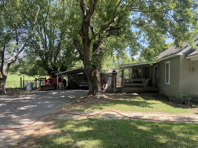 view of yard with a carport and fence