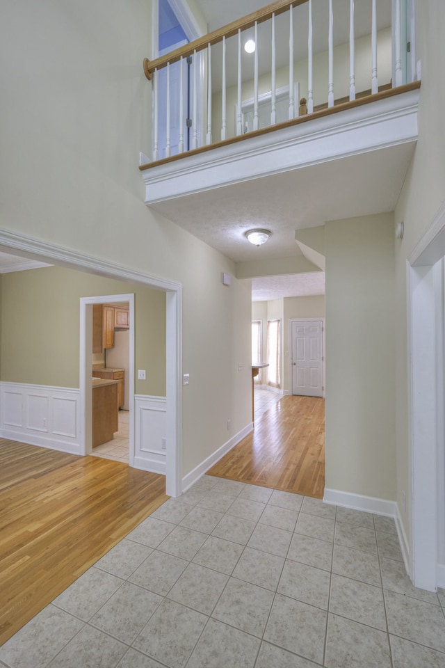 empty room featuring a high ceiling and light hardwood / wood-style flooring