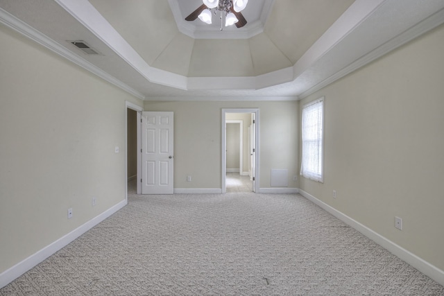 unfurnished bedroom with ceiling fan, carpet flooring, ornamental molding, and a tray ceiling