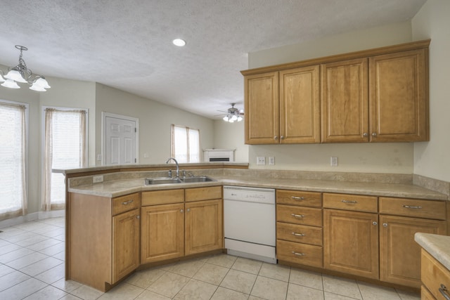 kitchen with light tile patterned floors, sink, kitchen peninsula, and dishwasher