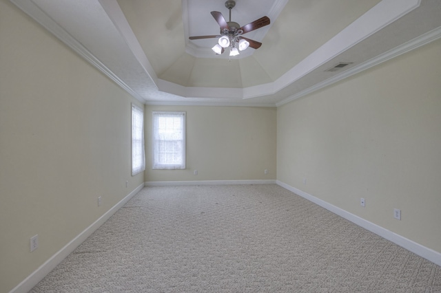 carpeted empty room featuring ceiling fan, a tray ceiling, and ornamental molding