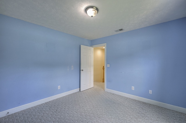 carpeted spare room featuring a textured ceiling