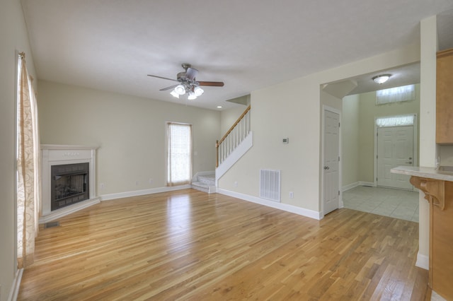 unfurnished living room featuring ceiling fan and light wood-type flooring