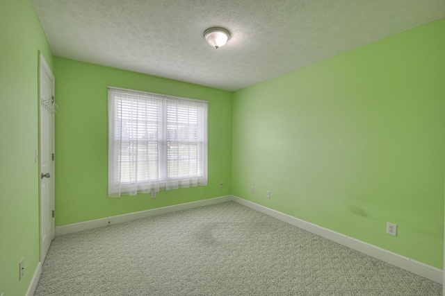 unfurnished room featuring a textured ceiling and carpet