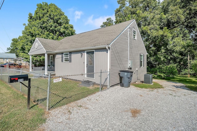 view of front of property featuring a front yard, roof with shingles, fence, and central air condition unit