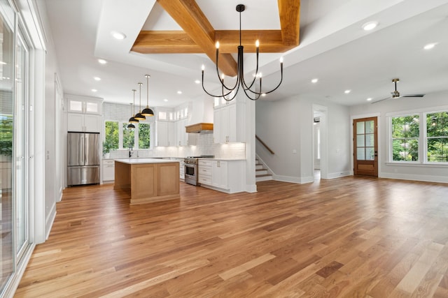 kitchen featuring open floor plan, light countertops, appliances with stainless steel finishes, and a center island