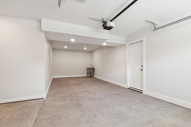 garage with a garage door opener, recessed lighting, and baseboards