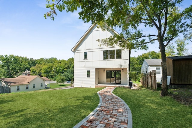 back of property with board and batten siding, a patio, fence, and a lawn