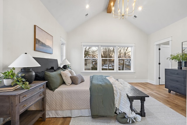 bedroom featuring high vaulted ceiling, wood finished floors, visible vents, and a notable chandelier