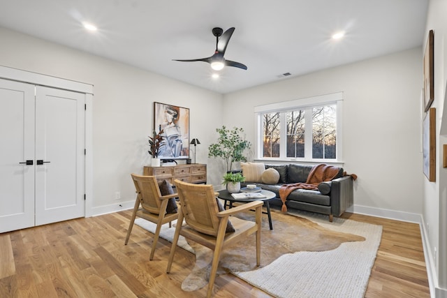 sitting room with light wood-style floors, visible vents, and baseboards