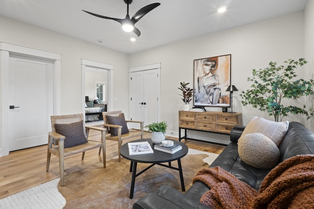 living area featuring baseboards, recessed lighting, a ceiling fan, and light wood-style floors