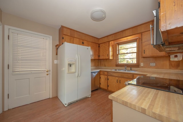 kitchen featuring dishwasher, sink, light hardwood / wood-style floors, and white refrigerator with ice dispenser