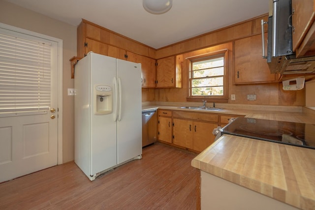 kitchen featuring dishwasher, white fridge with ice dispenser, sink, and light hardwood / wood-style flooring