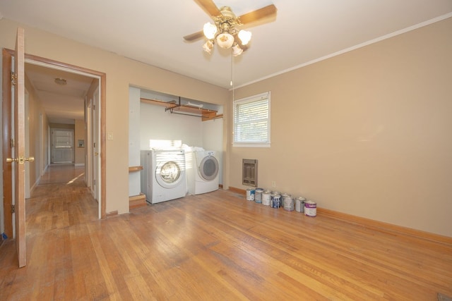 laundry room with washing machine and clothes dryer, crown molding, ceiling fan, light wood-type flooring, and heating unit