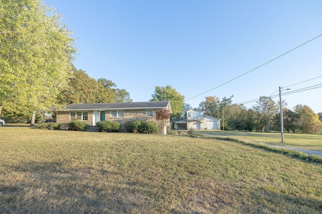 single story home featuring an outdoor structure and a front lawn