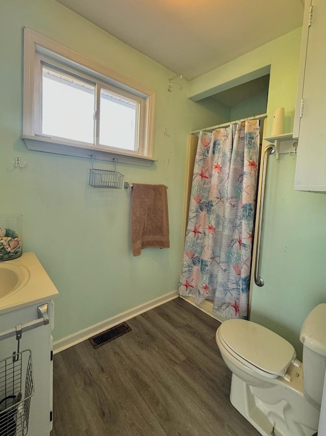 bathroom featuring hardwood / wood-style floors, vanity, a shower with shower curtain, and toilet