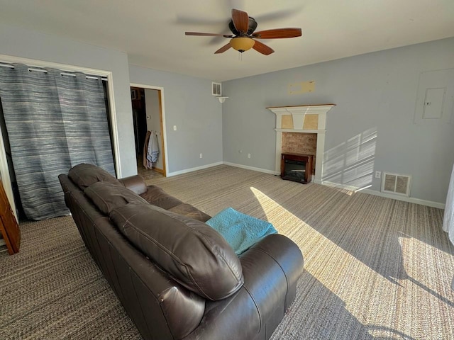 living room with ceiling fan, carpet floors, and a fireplace