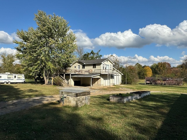 rear view of property featuring a wooden deck and a lawn