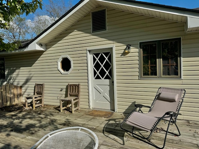 view of exterior entry featuring a wooden deck