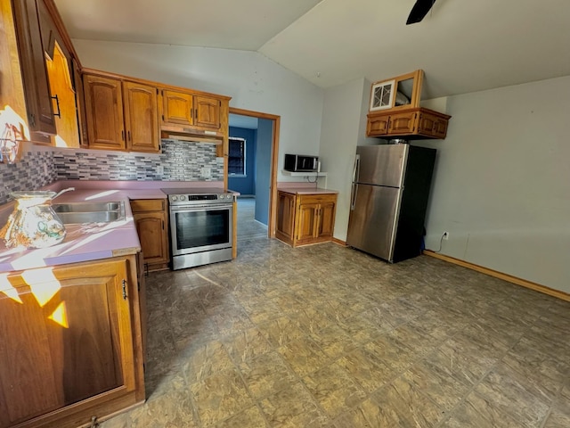 kitchen featuring ceiling fan, sink, stainless steel appliances, vaulted ceiling, and decorative backsplash