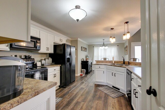 kitchen featuring pendant lighting, dark hardwood / wood-style flooring, white cabinets, sink, and black appliances