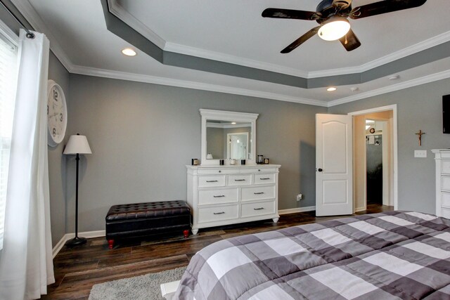 bedroom featuring ceiling fan, a raised ceiling, crown molding, and dark hardwood / wood-style flooring