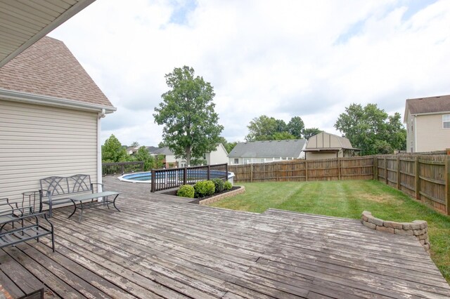 wooden deck with a lawn and a fenced in pool