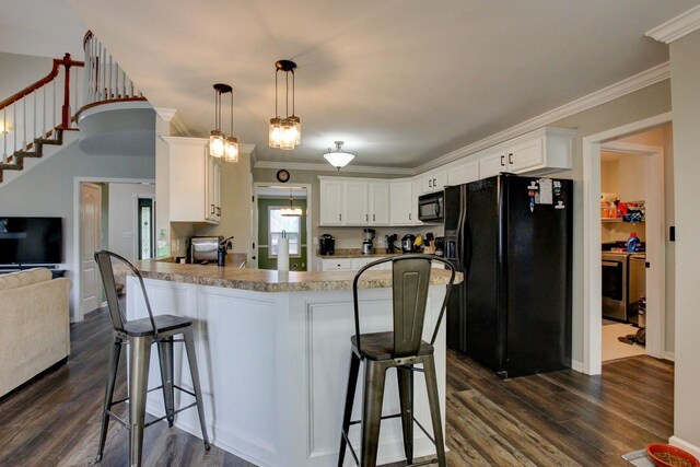 kitchen featuring dark wood-type flooring, crown molding, kitchen peninsula, black appliances, and white cabinets