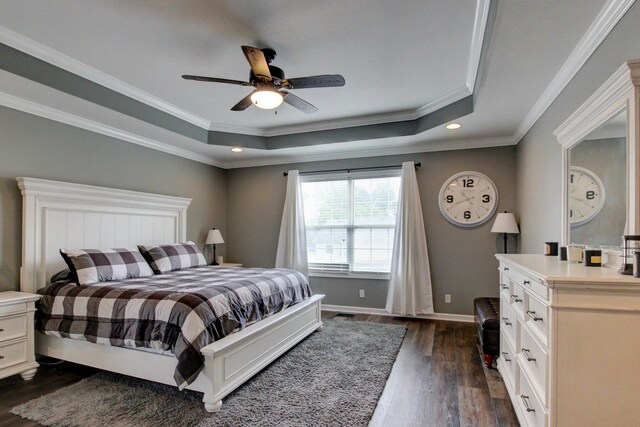 bedroom featuring ceiling fan, crown molding, a raised ceiling, and dark hardwood / wood-style flooring