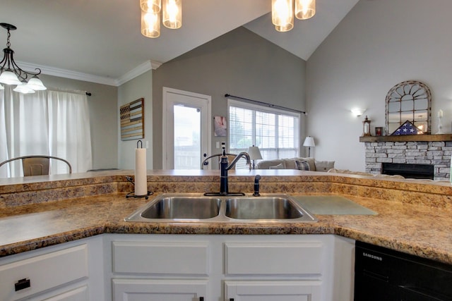 kitchen with sink, white cabinets, black dishwasher, vaulted ceiling, and a stone fireplace