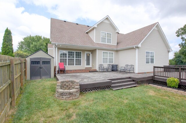 back of house featuring a storage shed, a yard, and a deck