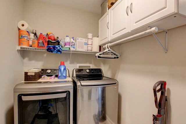 clothes washing area featuring independent washer and dryer and cabinets