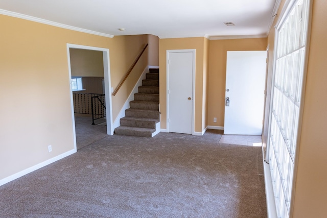 spare room with baseboards, carpet, ornamental molding, and stairs