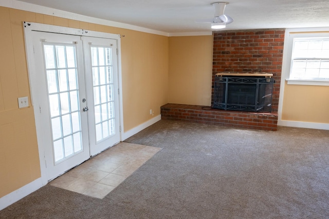 unfurnished living room with french doors, carpet, a fireplace, tile patterned flooring, and baseboards