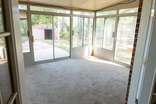 unfurnished sunroom featuring vaulted ceiling