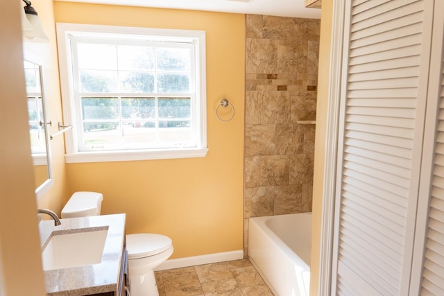 bathroom featuring toilet, vanity, and baseboards