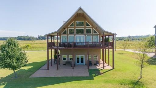 rear view of house with a patio, a yard, french doors, and a rural view