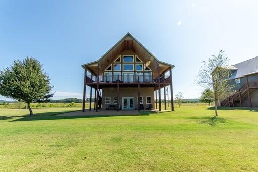 back of house with french doors, a lawn, and a deck