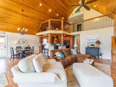 living room featuring ceiling fan with notable chandelier, high vaulted ceiling, wooden ceiling, and wood finished floors