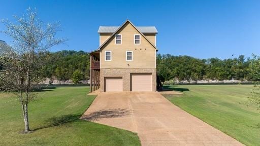 view of side of property with a garage, a yard, and driveway