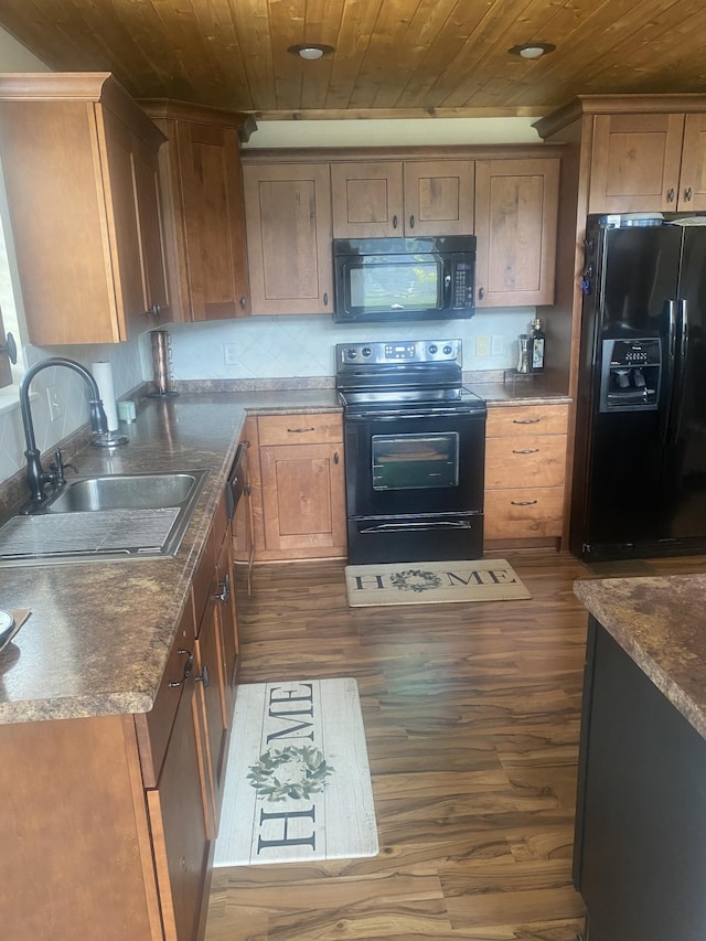 kitchen featuring dark wood-style floors, wooden ceiling, a sink, and black appliances