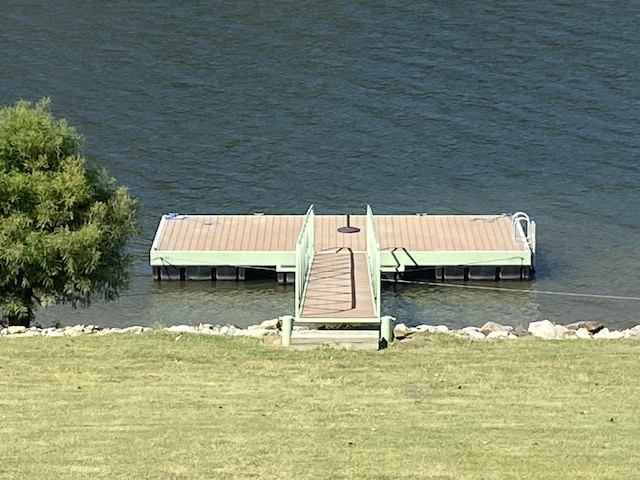 dock area featuring a water view and a lawn