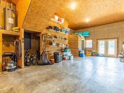 garage featuring french doors and electric water heater