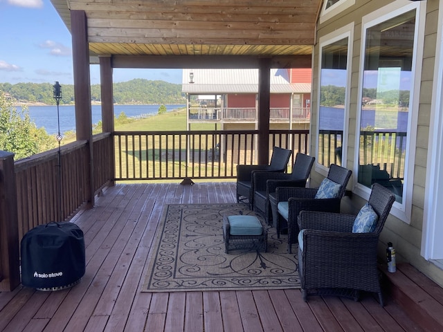 deck with a water view and an outdoor living space