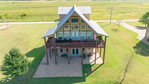 back of property featuring a patio area, a wooden deck, and a yard