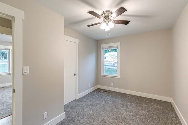 unfurnished bedroom featuring ceiling fan and dark colored carpet