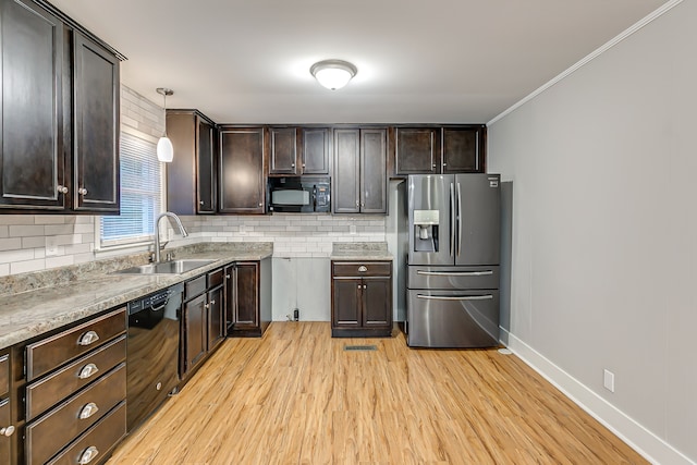 kitchen featuring light wood-type flooring, hanging light fixtures, ornamental molding, sink, and black appliances